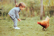 © nicoletaionescu - Happy Little Girl Playing with a Hen in the Countryside