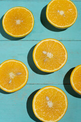 Wall Mural - Orange halves on turquoise background