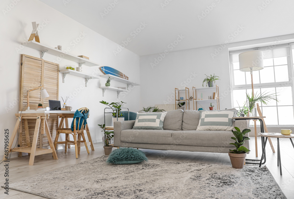 Stylish grey sofa in modern interior of living room