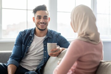 Wall Mural - Happy middle-eastern man sharing ideas with his girlfriend