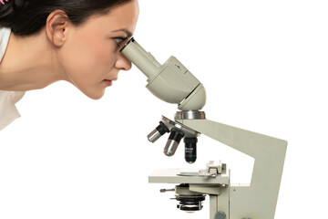 Wall Mural - Surprised female scientist looking through a microscope, close up