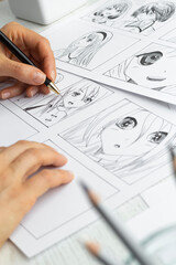 Manga style. The artist draws sketches of anime comics. Storyboard of characters on paper.