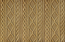 Beige Background Knitted Fabric With A Pattern. Knitted Arans Close-up