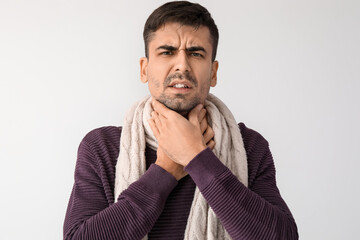 Canvas Print - Ill young man with sore throat on white background