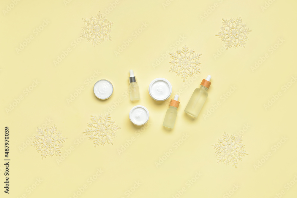 Composition with different cosmetic products and beautiful snowflakes on color background