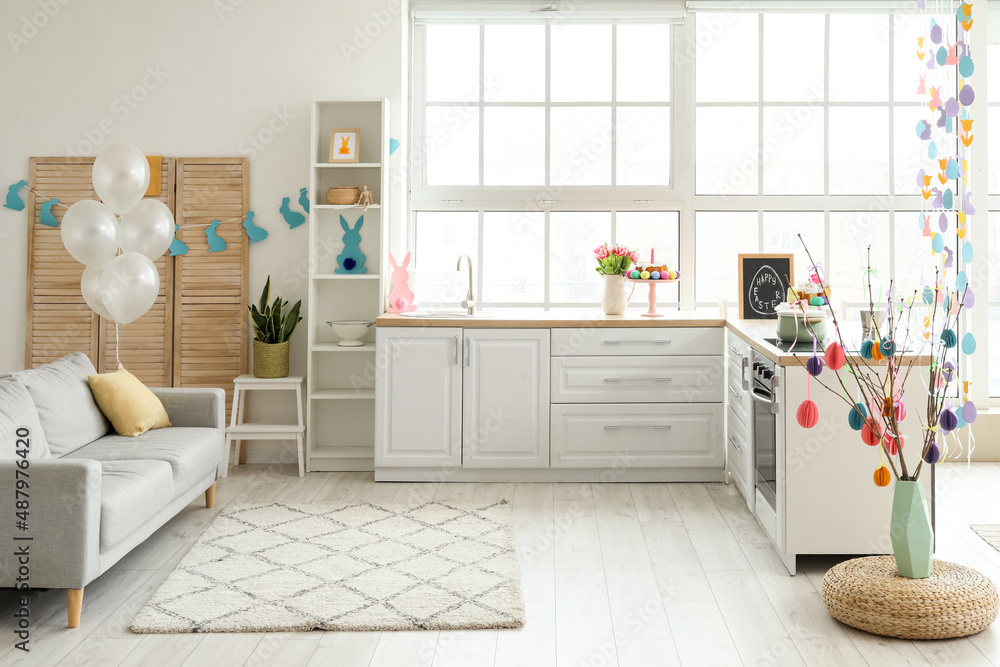 Interior of light kitchen with white counters, window and Easter decor