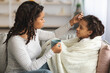 © Prostock-studio - Black mother giving her ill daughter hot drink