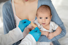 Unrecognizable Doctor Or Nurse Putting Adhesive Plaster On Baby Arm After Injection