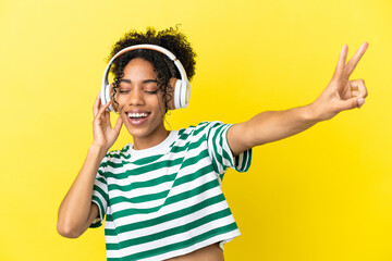 Sticker - Young african american woman isolated on yellow background listening music and singing