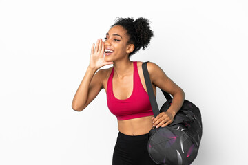 Wall Mural - Young sport african american woman with sport bag isolated on blue background shouting with mouth wide open to the side