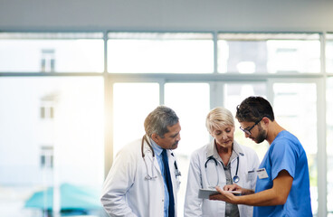 Sticker - Smart doctors use smart apps. Shot of a team of doctors using a digital tablet together in a hospital.