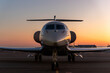 © Kyryl Gorlov - Scenic front view modern luxury expensive private jet plane parked airport taxiway hangar warm colorful dramatic evening warm sunset sun light sky background. Executive aicraft vip travel concept