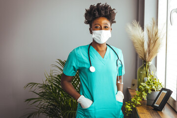 Medical Doctor Indoors Portraits. Portrait of a confident doctor working at a hospital. Waist up portrait of beautiful African-American nurse posing confidently while standing with arms crossed