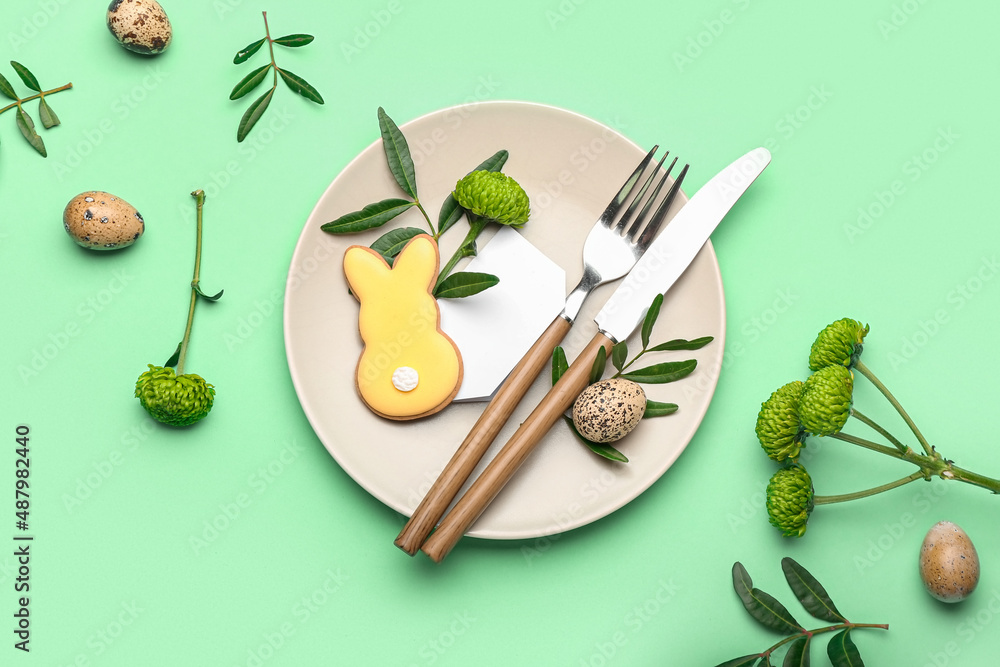 Stylish table setting with Easter cookie on turquoise background