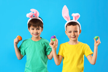 Poster - Cute little boys with bunny ears and Easter eggs on blue background