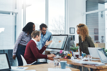 Poster - Nothing boosts productivity like teamwork. Shot of a group of colleagues using a computer together in a modern office.