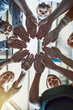 © Nola V/peopleimages.com - Success is in the hands of their team. Low angle shot of a group of colleagues joining their hands in solidarity at work.