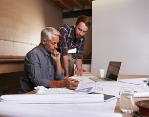 Canvas Print - turning his vision into reality. an architect drawing up plans.