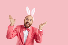 Ta Da It's Me Aren't You Surprised. Happy Guy In Bunny Costume Having Fun On Easter Day. Excited Smiley Goofy Bearded Man Wearing Suit, Bowtie And Funny Ears Playing Peekaboo On Pink Studio Background
