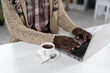 © Svyatoslav Lypynskyy - African American man typing on laptop with a cup of coffee next to him wearing beige sweater sitting at the table at the campus cafeteria. Drops of coffee on spoon isolated on white table