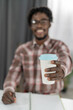 © Svyatoslav Lypynskyy - Selective focus on African american man hand with cardboard cup or disposable cup for coffee or tea. White disposable cup with blue plastic lead in mans hand. Disposable dishes concept