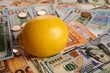 Lemon - photo on cash bills. Yellow lemon is laying on Euro and dollar bills. Real money under citrus fruit. Commercial result of harvest in agriculture. Real gain. Paper fiat money of USA and Europe.
