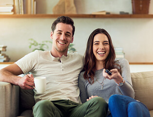 Canvas Print - We never miss an episode. Portrait of a happy young couple relaxing on the sofa and watching tv together.