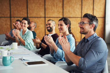 Sticker - The creative process. Shot of a group of colleagues clapping together at a table in an office.