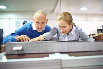 Aufkleber - Quality assurance throughout the printing process. Two publishers assessing the quality of printed work in a factory.