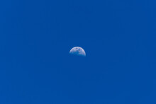 A Mesmerizing Shot Of The Half-moon In The Clear Blue Sky