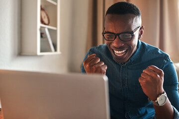 Poster - All my hard work is finally paying off. Cropped shot of a handsome young businessman sitting alone in his home office and feeling excited while using his laptop.