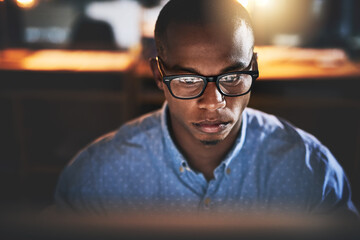 Poster - Success happens when hardwork and dedication come together. Cropped shot of a handsome young businessman using a computer during a late night in a modern office.