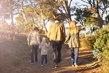 Poster - Time for a family adventure. Rearview shot of a young family walking along a forest trail.