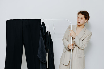 portrait of a young woman In a light classic suit clothes hanger light background unaltered