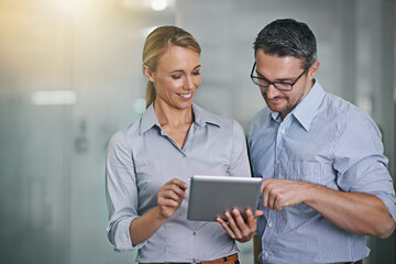 Canvas Print - Achieving success within one touch. Cropped shot of two businesspeople working on a digital tablet.