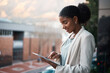 © Chanelle Malambo/peopleimages.com - Go digital and get it done today. Shot of a young businesswoman using a digital tablet out on the balcony of a modern office.