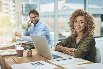 Aufkleber - We do what we do for the love of it. Portrait of a young woman working at her desk with her colleague in the background.