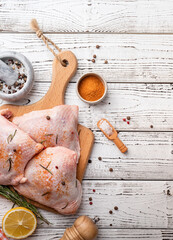 Wall Mural - Sliced chicken thighs with skin on a cutting board. White wooden background. Top view. Copy space