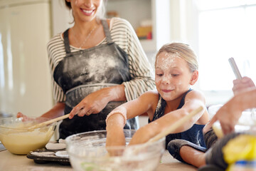 Poster - Baking up a storm. Shot of two little girls baking with their mother in the kitchen.