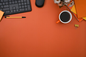 Wall Mural - top view stylish workspace with wireless keyboard, coffee cup and notebooks on orange background.