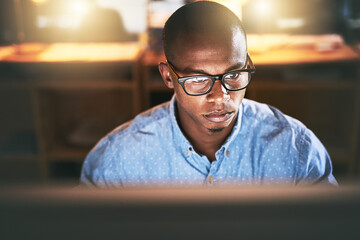 Poster - This is what you do when youre passionate about success. Shot of a young businessman using a computer during a late night in a modern office.