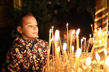 Boy with candle in russian orthodox church