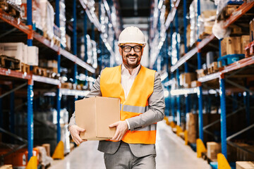 Wall Mural - A supervisor holding box with order at storage and smiling at the camera.