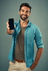 Aufkleber - Take a look and tell me what you think. Studio portrait of a handsome young man holding a cellphone with a blank screen against a grey background.