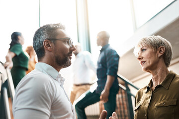 Aufkleber - Exchanging some business advice. Shot of two businesspeople talking to each other while standing on a stairwell.