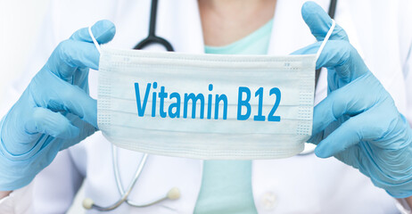 Wall Mural - Doctor holding a protective face mask text with Vitamin B12, Medical concept