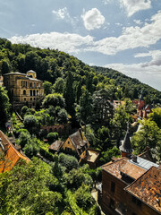 Sticker - A scenery of aged buildings surrounded by trees on a mountain