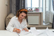 Caucasian Woman in white shirt and orange hoop sign documents at home. Remote work. Sign model release. Filling out documents positive paperwork