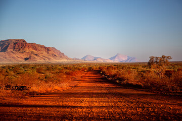 One of the most beautiful red dirt-roads in the Karijini National Park in Western Australia at sunset.