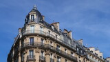 Fototapeta  - Immobilier ancien à Paris, architecture de la façade d'un immeuble d’angle haussmannien avec balcon (France)